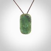 This picture shows a hand carved face pendant. It is a varied green colour which is quite beautiful. Although a medium piece, it is a wonderful, delicate piece of jewellery. The cord is hand plaited and adjustable so that you can position the pendant where it suits you best. Delivery is free worldwide.